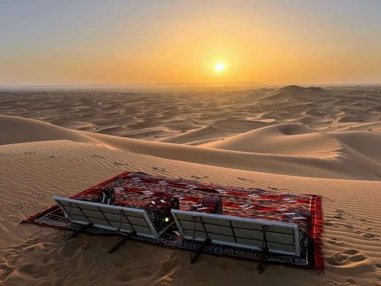 Private picnic with carpets on the Erg Chebbi Dunes at sunset in the Sahara Desert, Morocco