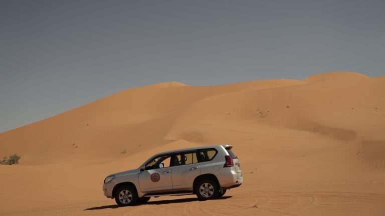 Toyota Prado with Saharaï logo on the side driving across the Erg Chebbi Dunes in Merzouga