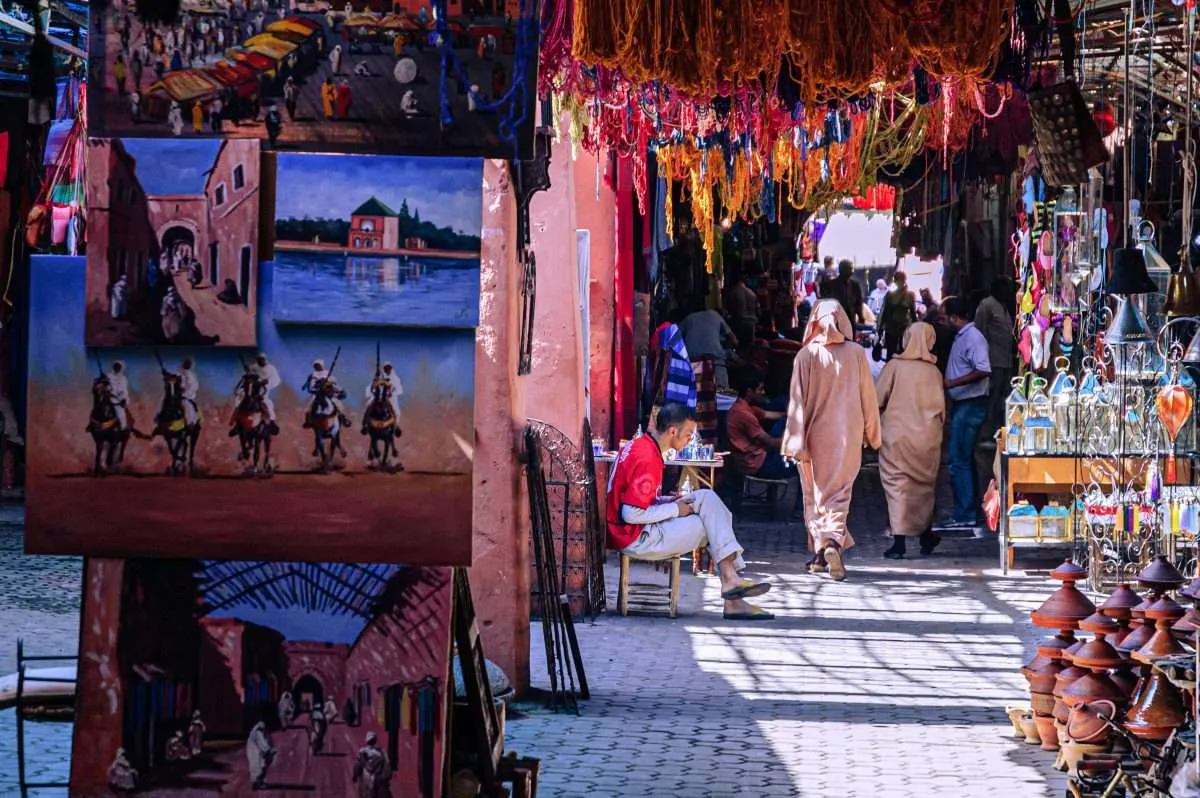 Colourful Marrakech medina alley with hanging textiles in Morocco