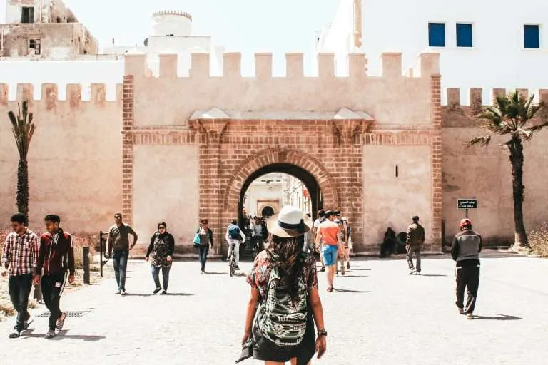Traveller walking toward a historic gate in Essaouira medina