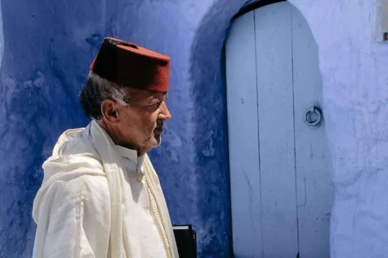 Moroccan man wearing a Fes in the streets of Chefchaouen, Morocco's Blue City