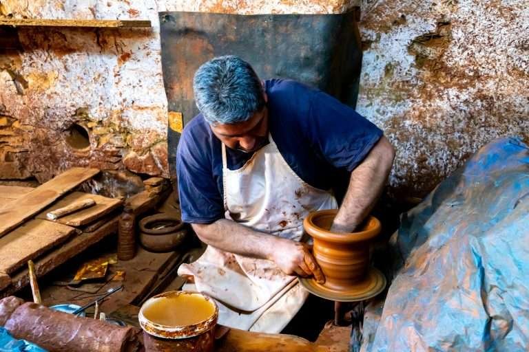 Moroccan potter shaping clay by hand in a workshop