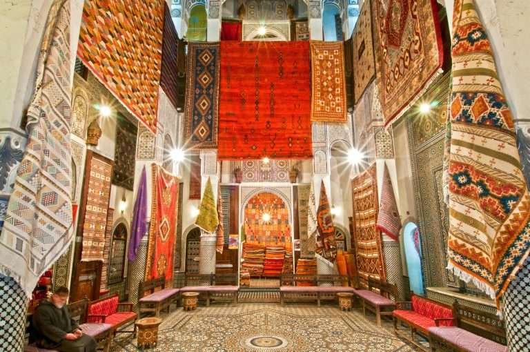Richly decorated Moroccan interior with rugs and carved architecture in a souk