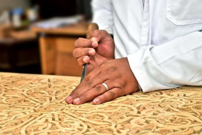Artisan carving intricate plasterwork by hand in Morocco
