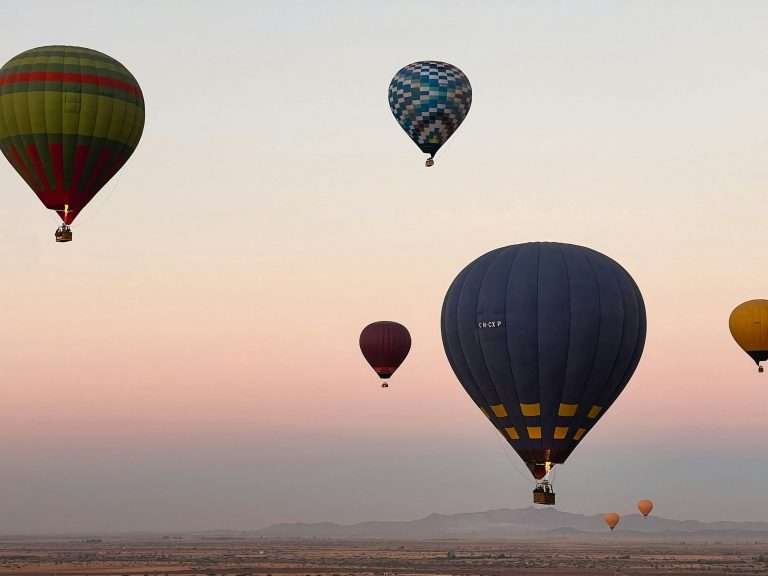 Hot air balloons floating over the Marrakech region at sunrise