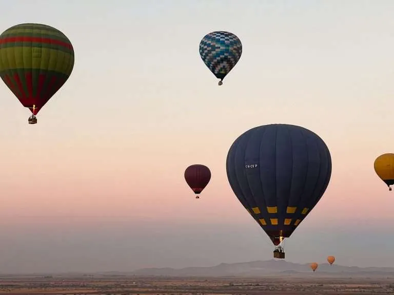 Hot air balloons floating over the Marrakech region at sunrise